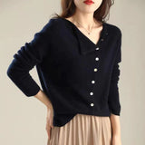 Donna indossa maglione nero con bottoni bianchi e gonna beige. Moda autunnale elegante, abbigliamento casual chic, stile minimalista.