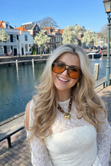 Model wearing black frame orange lens sunglasses front view