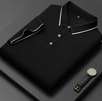 Camicia polo nera piegata con colletto a contrasto, bottoni bianchi, su sfondo grigio. Orologio elegante con cinturino in pelle accanto.